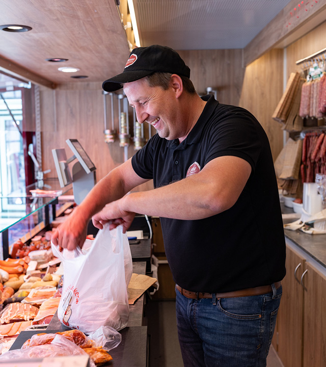 Esselmann Verkaufsfahrzeug für Fleisch und Wurst kaufen – Metzger packt Wurstwaren ein